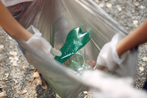 osoby zbierające odpady plastikowe do worka