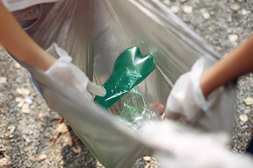 osoby zbierające odpady plastikowe do worka